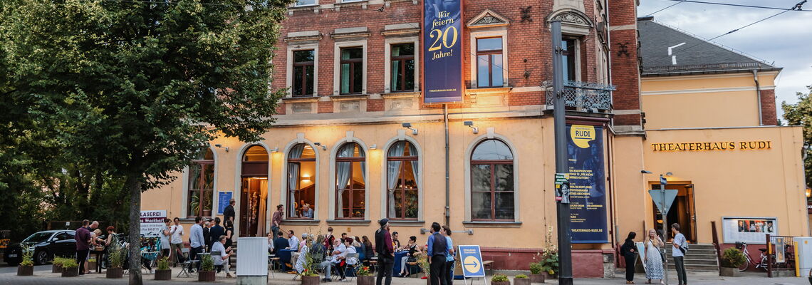 Hausansicht mit vielen Gästen anlässlich eines gemeinsamen Festes