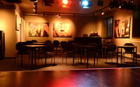Theaterkeller mit Blick auf die Sitzgruppen. Stühle stehen an Tischen.